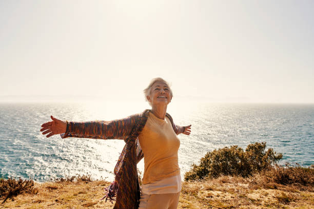 shot of a senior woman with her arms outstretched at the beach